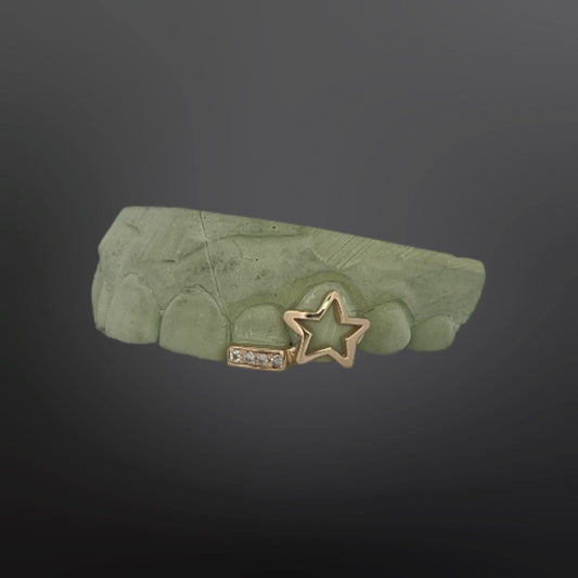 Custom gold star outline grillz with iced out stone bar cap on dental mold