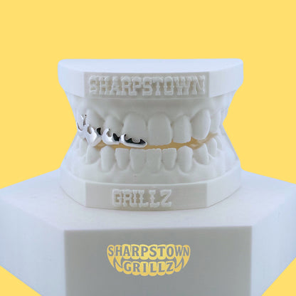 Sculpted flame licks silver open frame grillz for upper arch teeth mold.