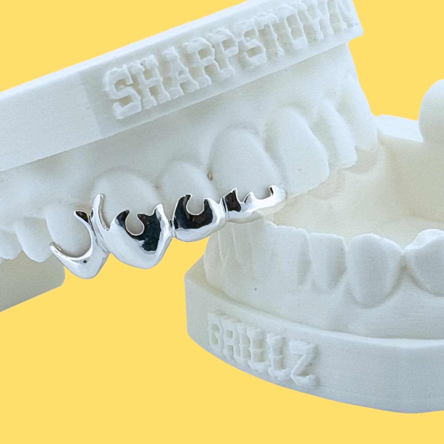 Custom 925 silver flame cutout teeth caps set on upper front teeth impression.