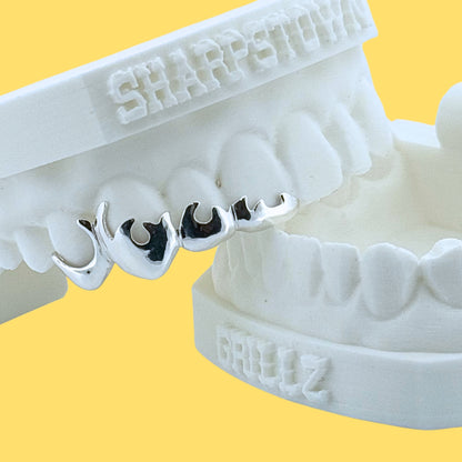 Custom 925 silver flame cutout teeth caps set on upper front teeth impression.