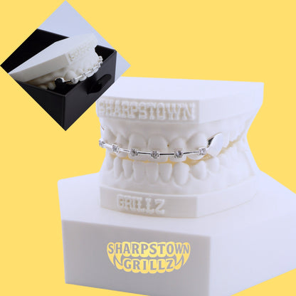 Custom 925 silver tooth bar with cubic zirconia stone bezel settings on white dental model.