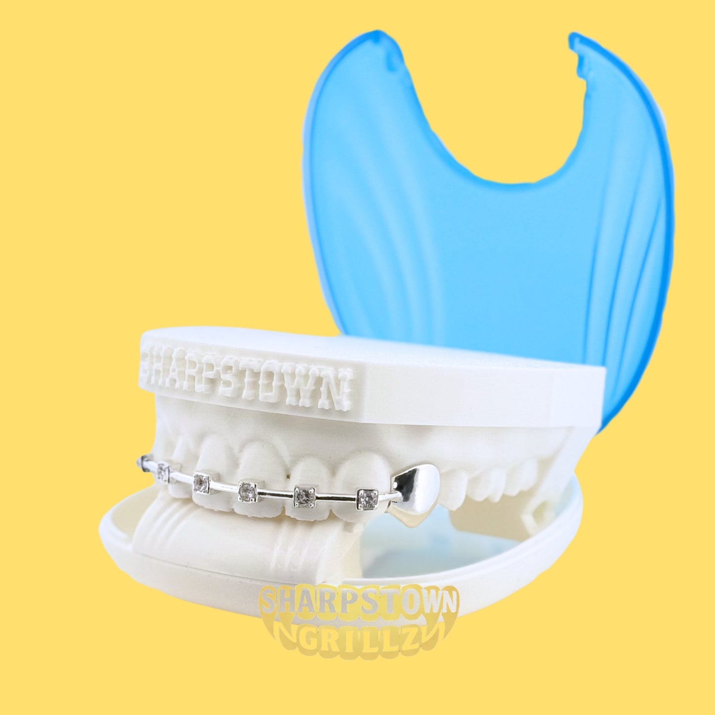 Minimalist iced braces bar grill cap set across upper front teeth mold on a yellow background.