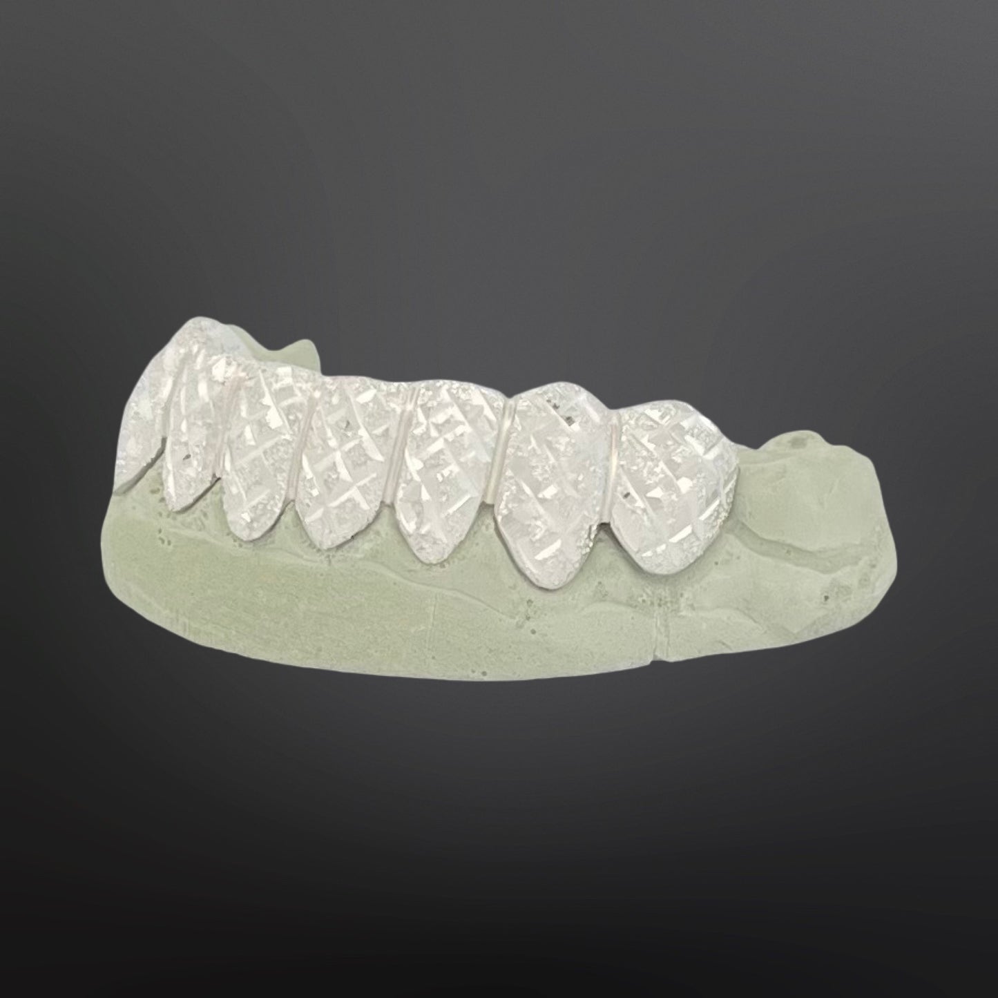 Dental model with white teeth on a dark gray background