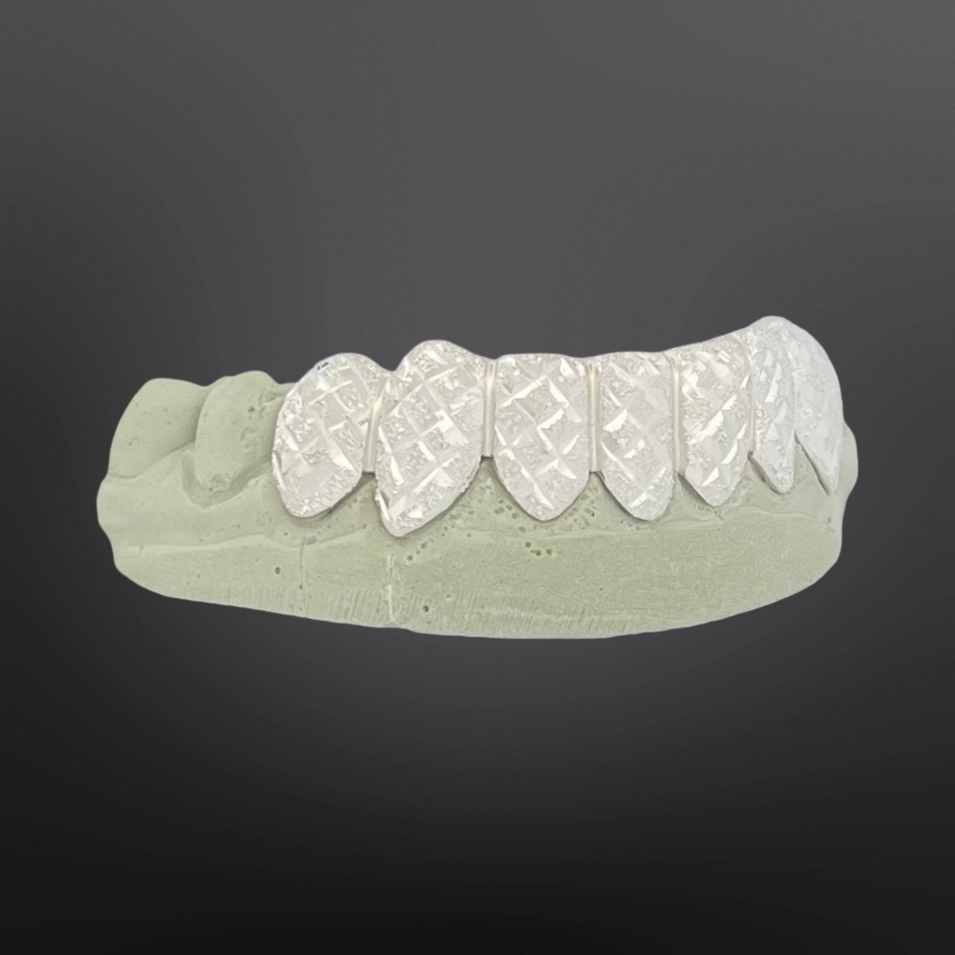 Dental model with white ceramic teeth on a gray background