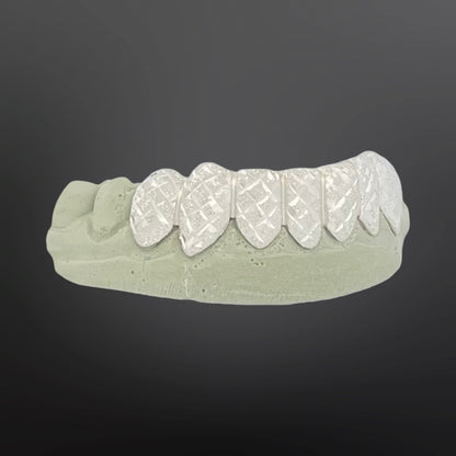 Dental model with white ceramic teeth on a gray background