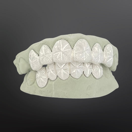 Set of diamond-studded grillz on a gray background