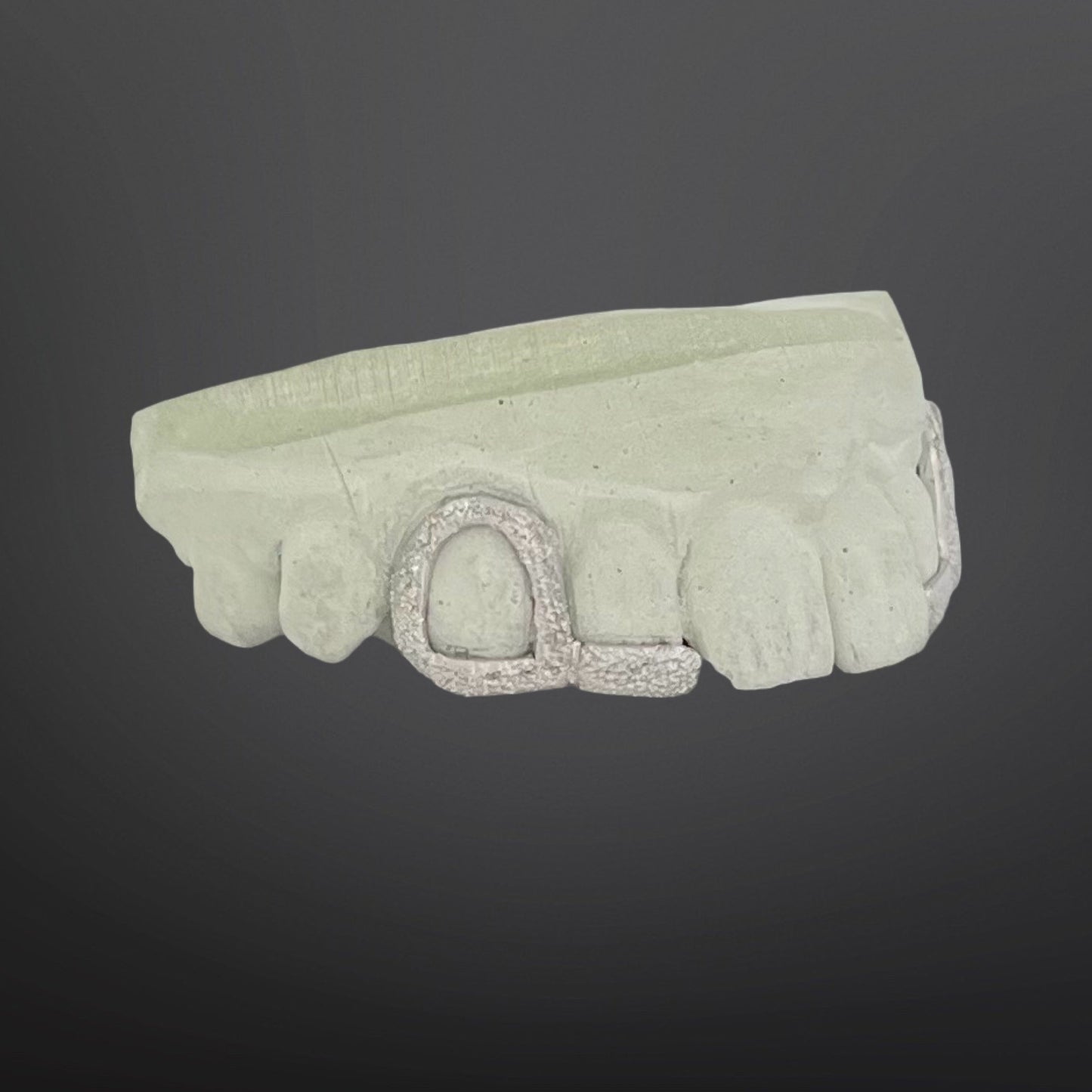 Light green headband with a decorative clasp on a dark gray background