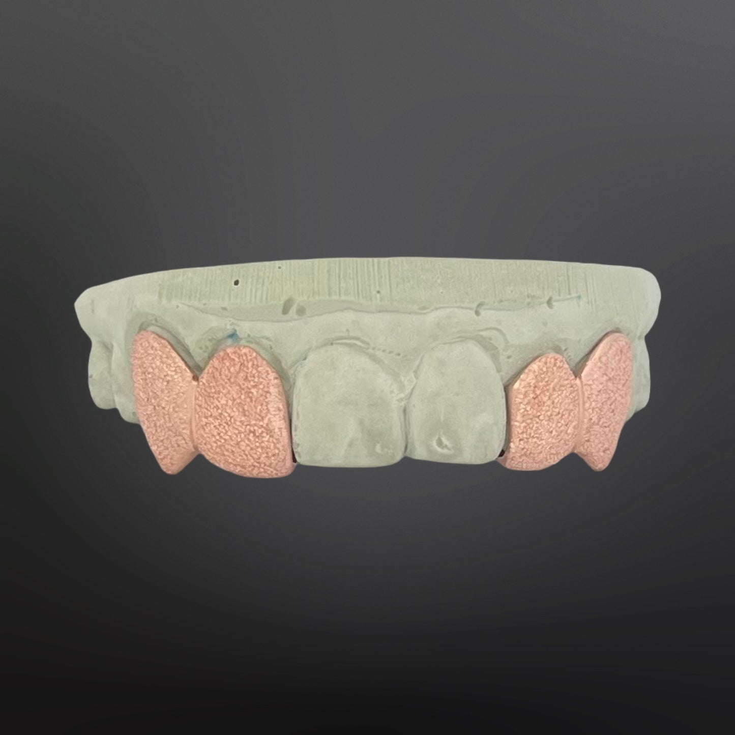 Teeth-shaped grill with pink and gray design on a dark background