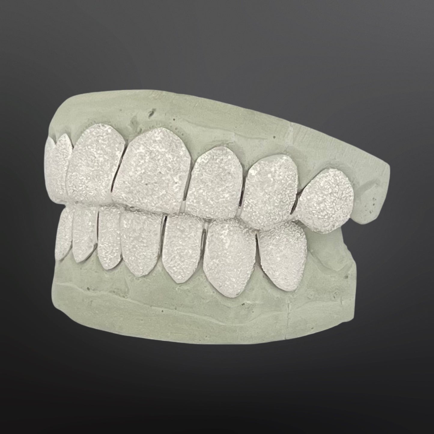 Dental model with glittery teeth on a dark background