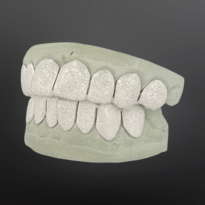 Dental model with glittery teeth on a dark background