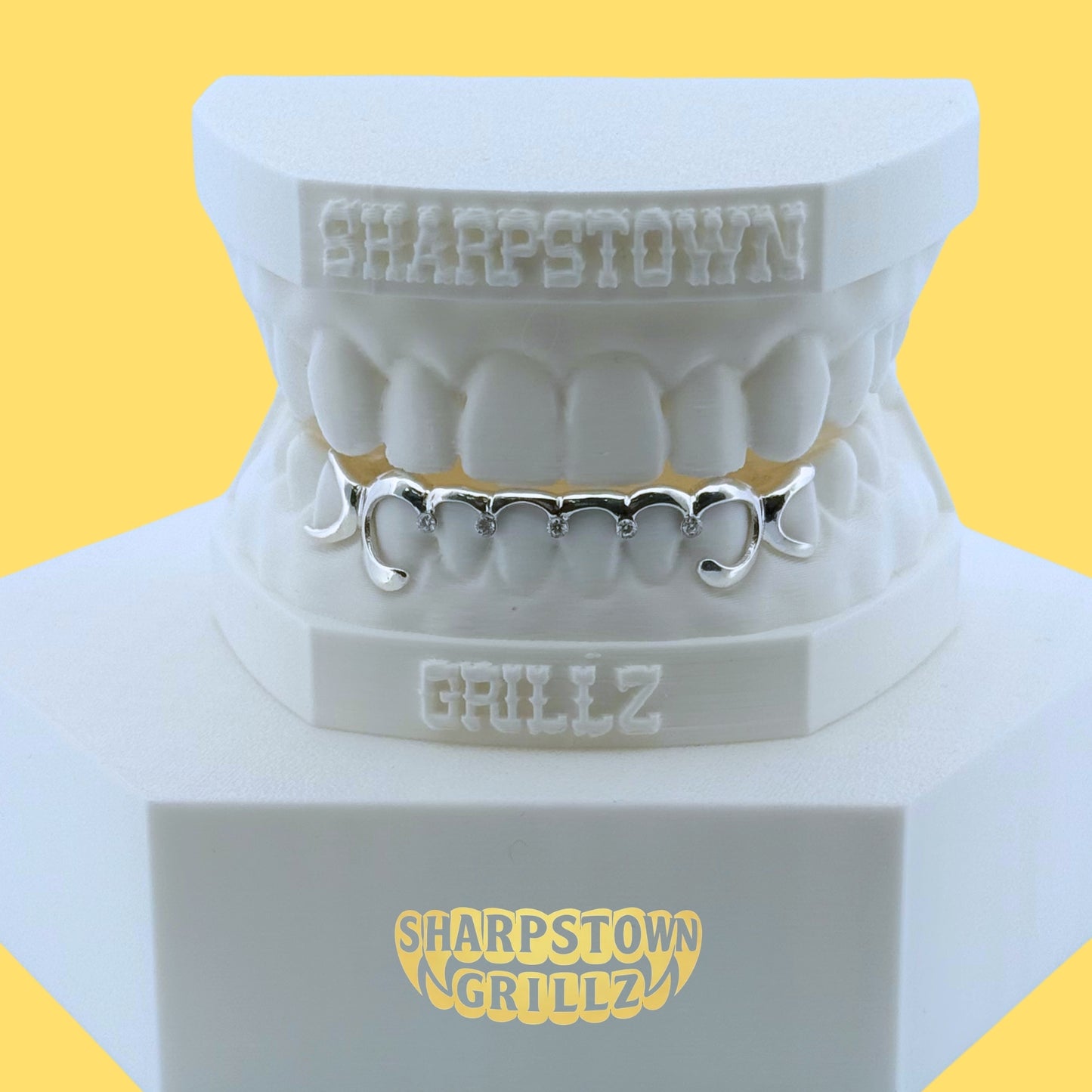 Custom yellow gold top grillz with diamond cut crosshatch pattern and diamond dust texture on a white dental cast.