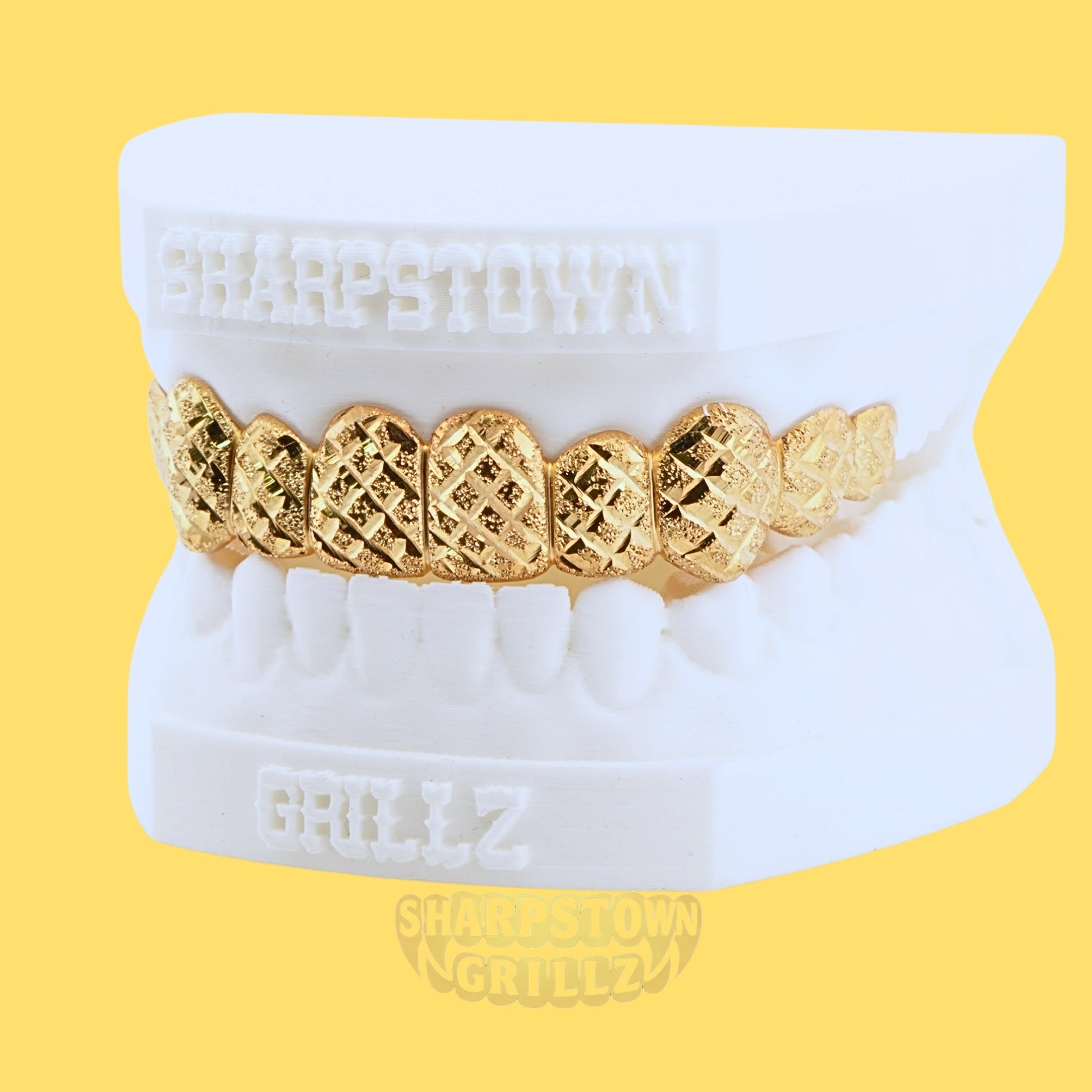 Front view of custom top gold grillz with laser diamond cut pattern and polished borders.