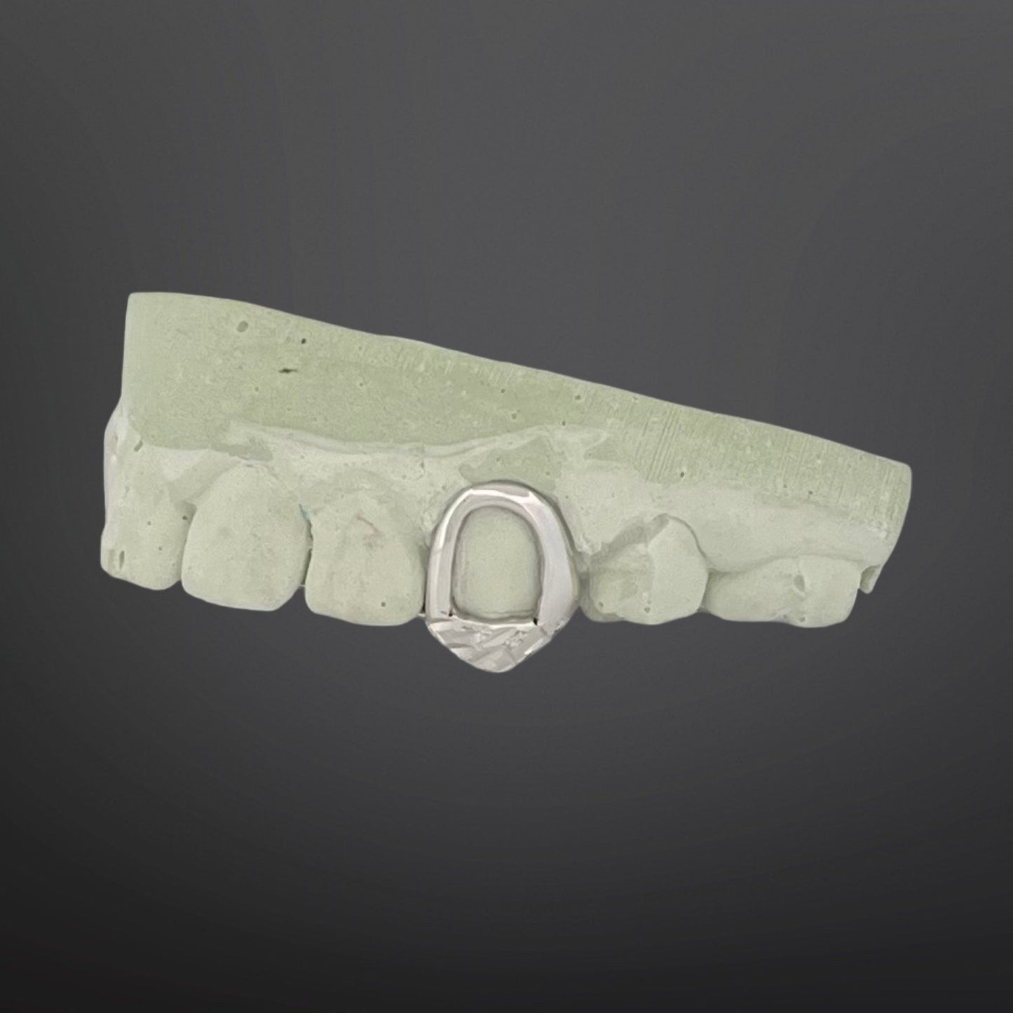Green stone-like belt buckle with a silver buckle on a dark gray background