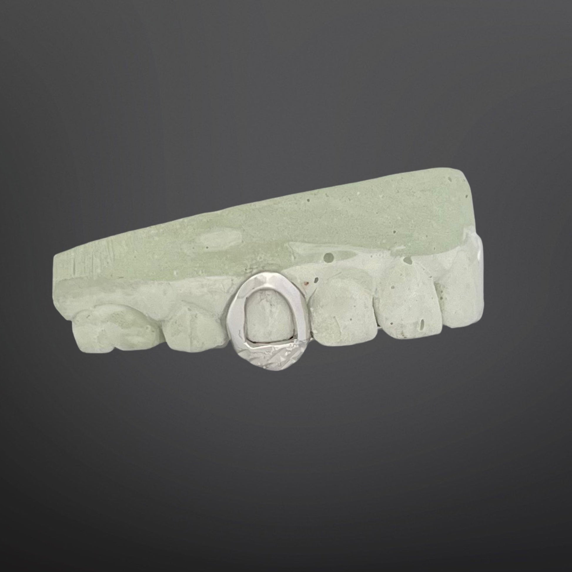 Green stone bracelet with a silver clasp on a dark background