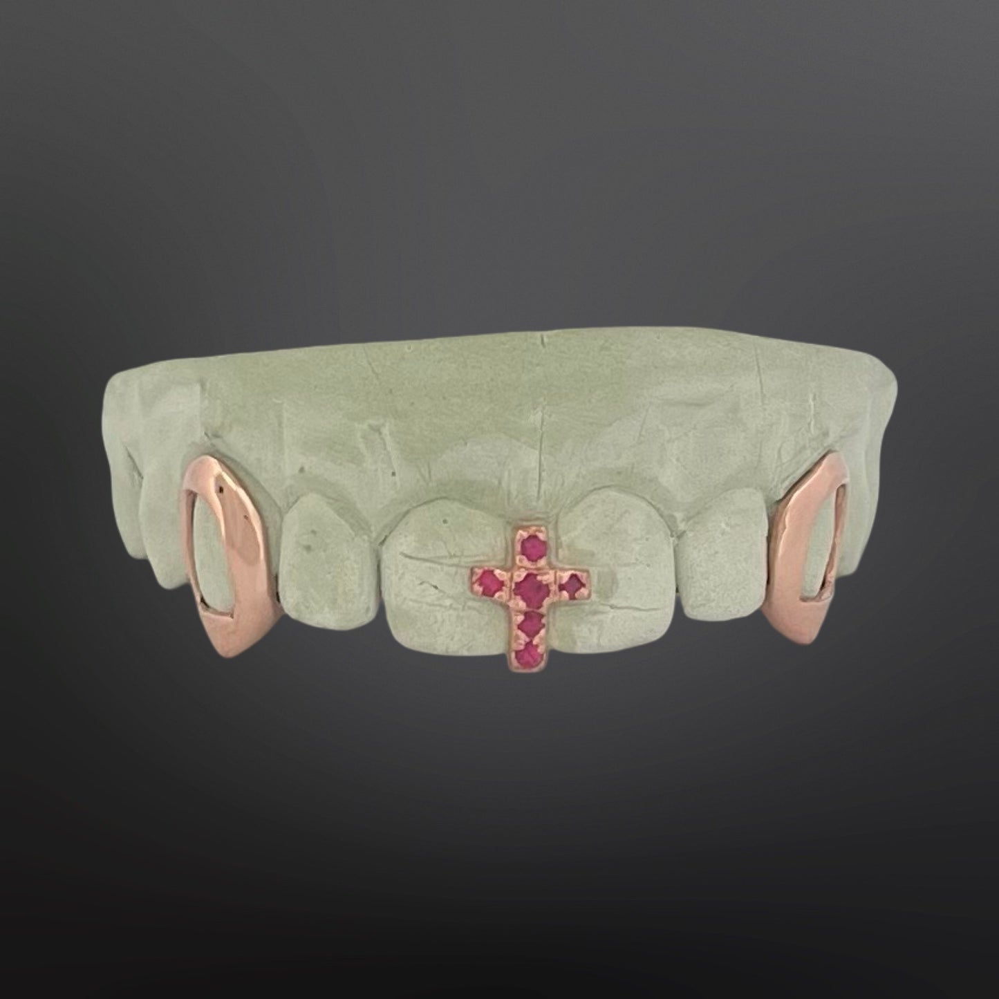 Teeth grill with cross and gemstones on a dark background