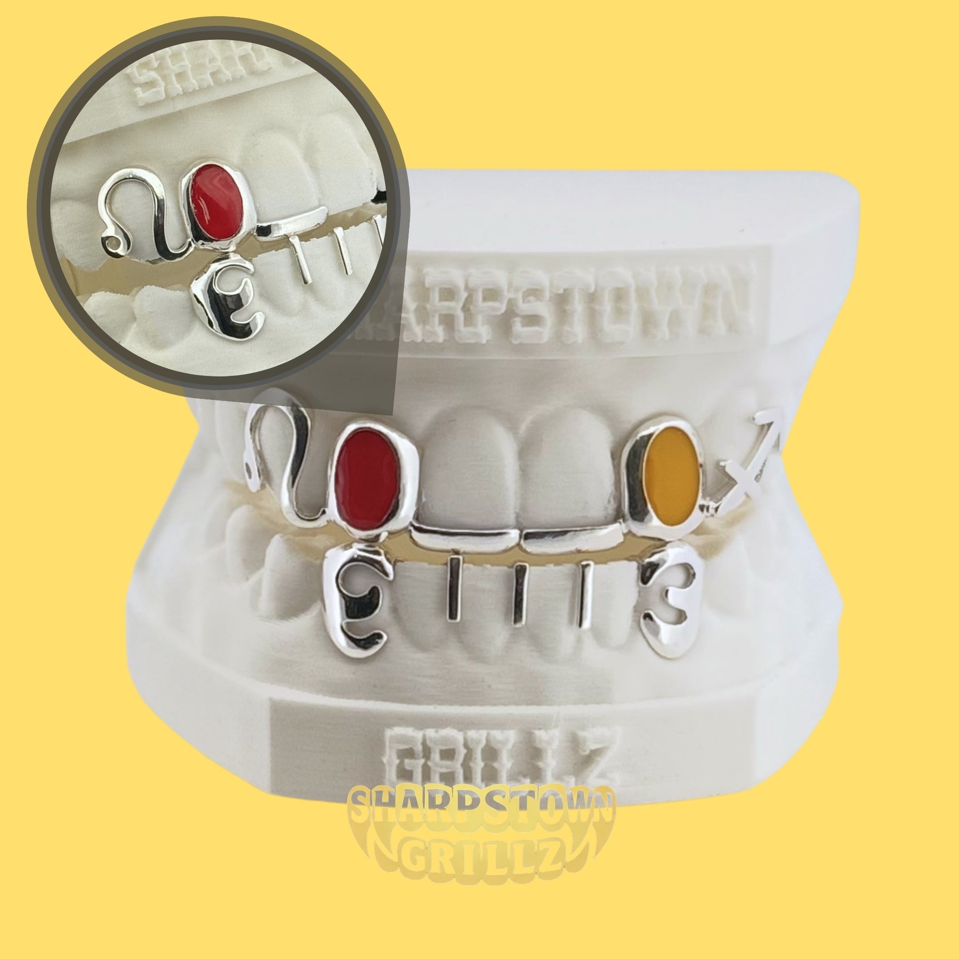 Silver 925 custom open frame letter and number grill set displayed on a white Sharptown Grillz dental model.