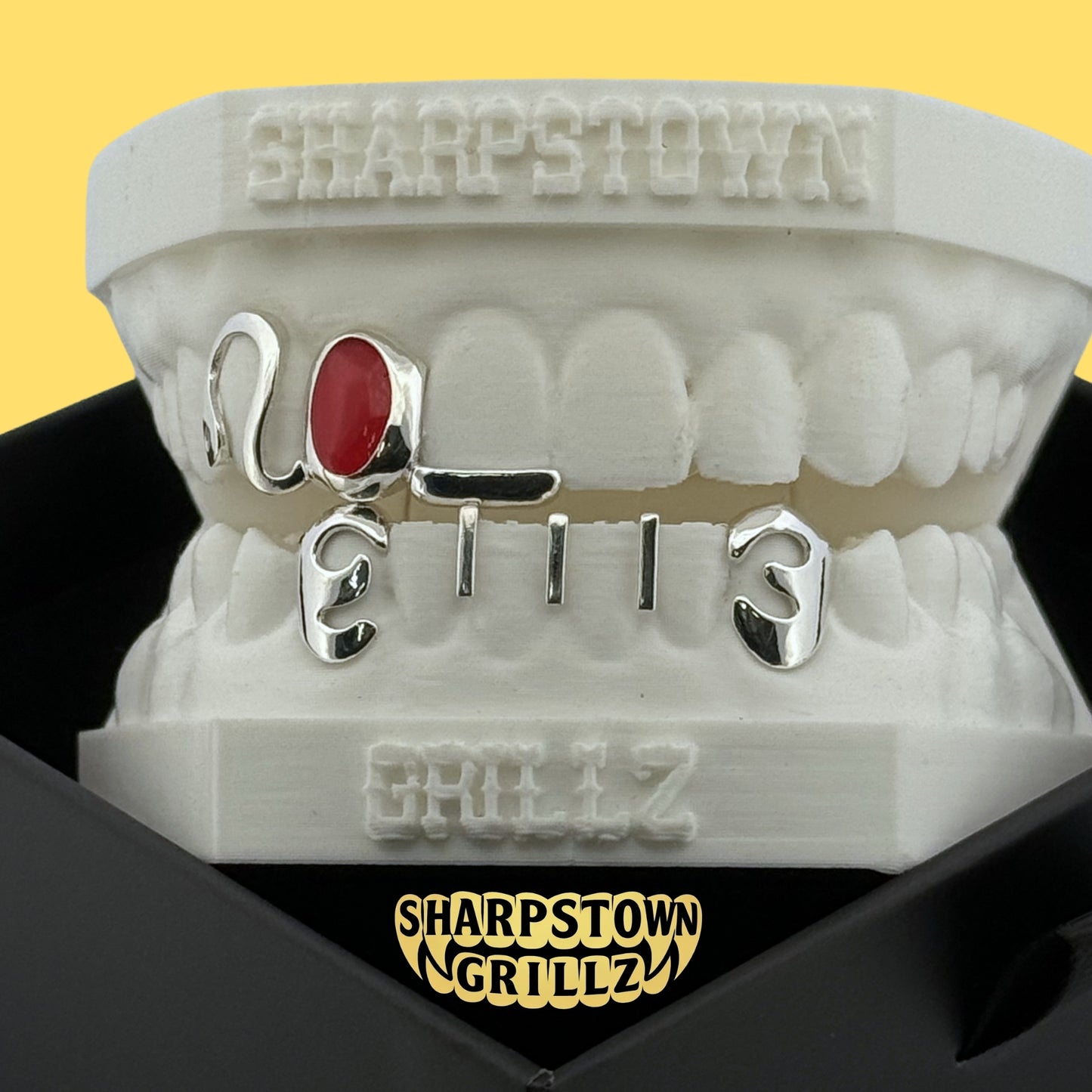 Custom 2003 date open face teeth grillz featuring red and yellow oval enamel inlay fills.