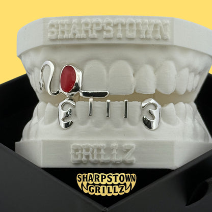 Custom 2003 date open face teeth grillz featuring red and yellow oval enamel inlay fills.