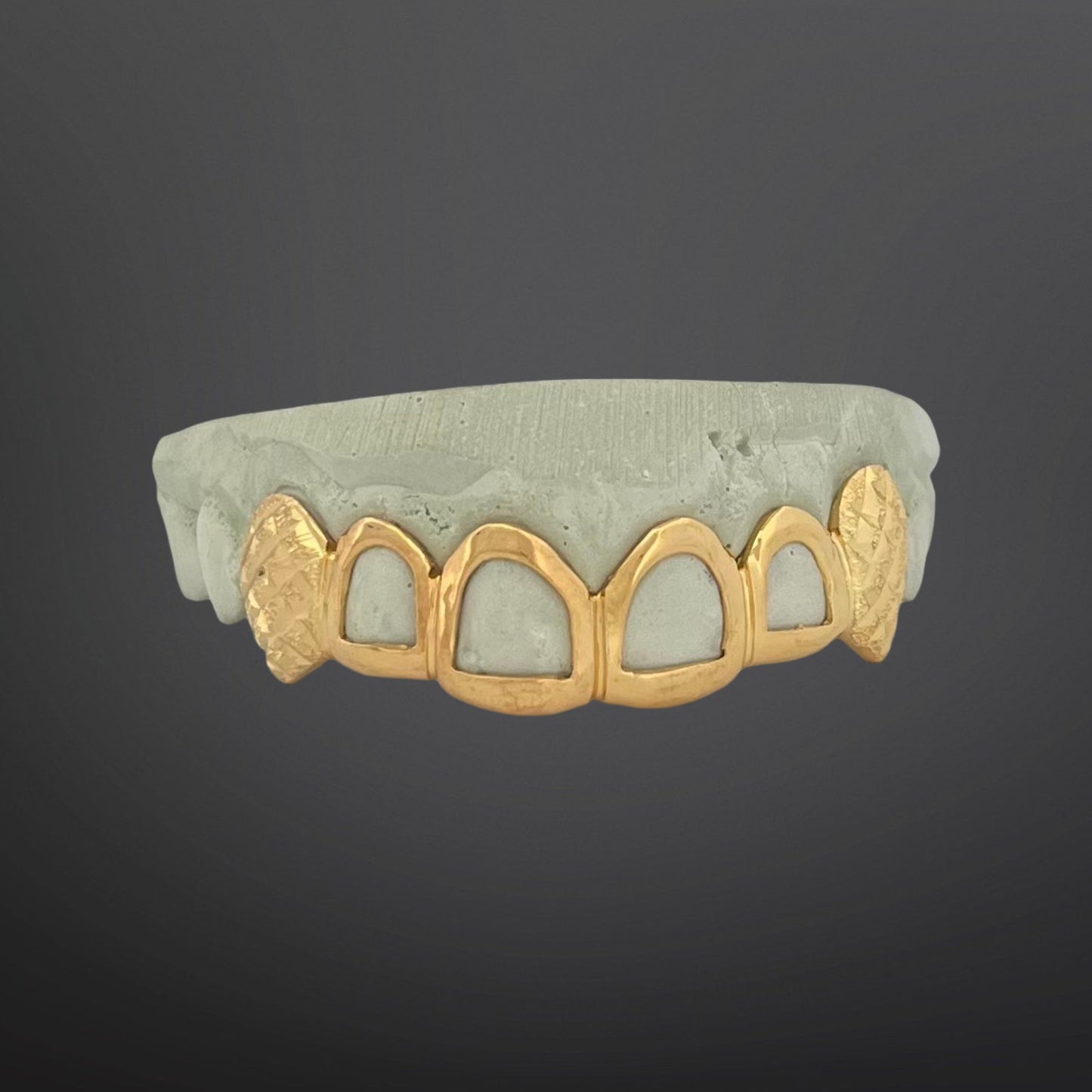 Gold grill on a dark gray background