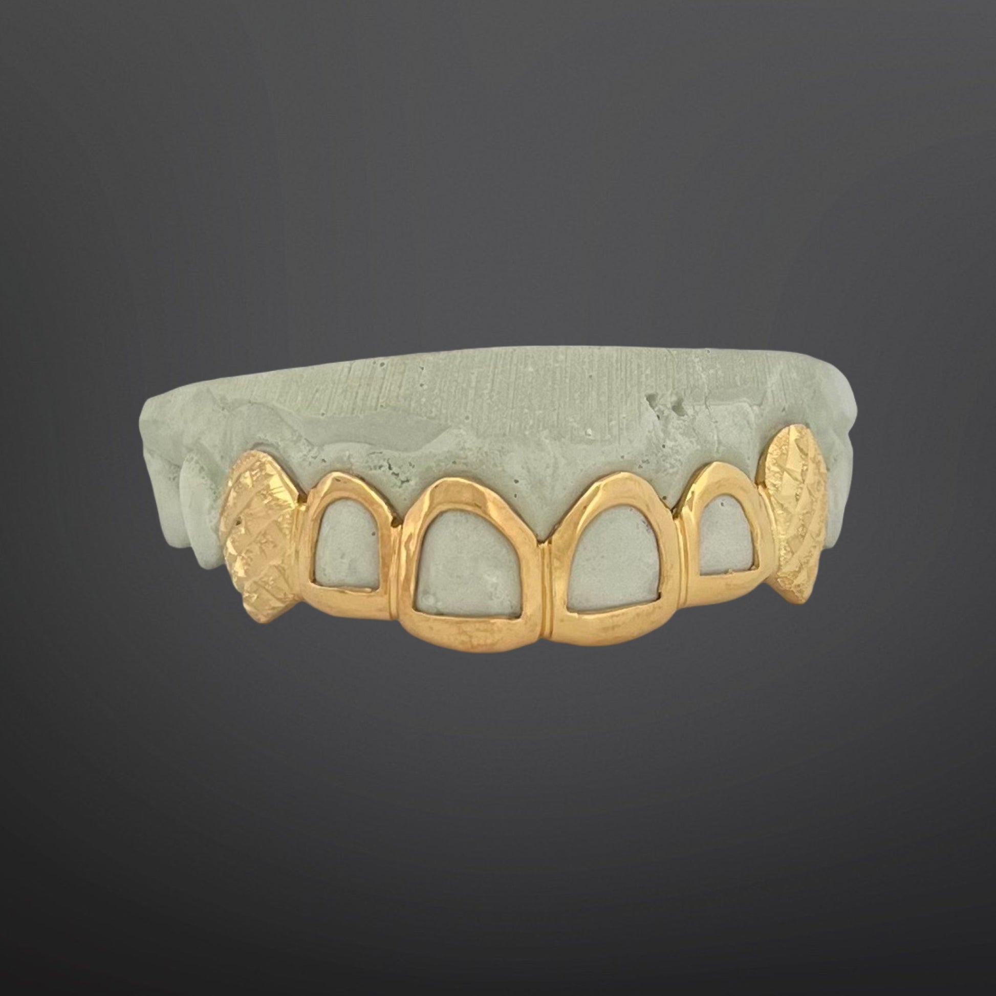 Gold grill on a dark gray background