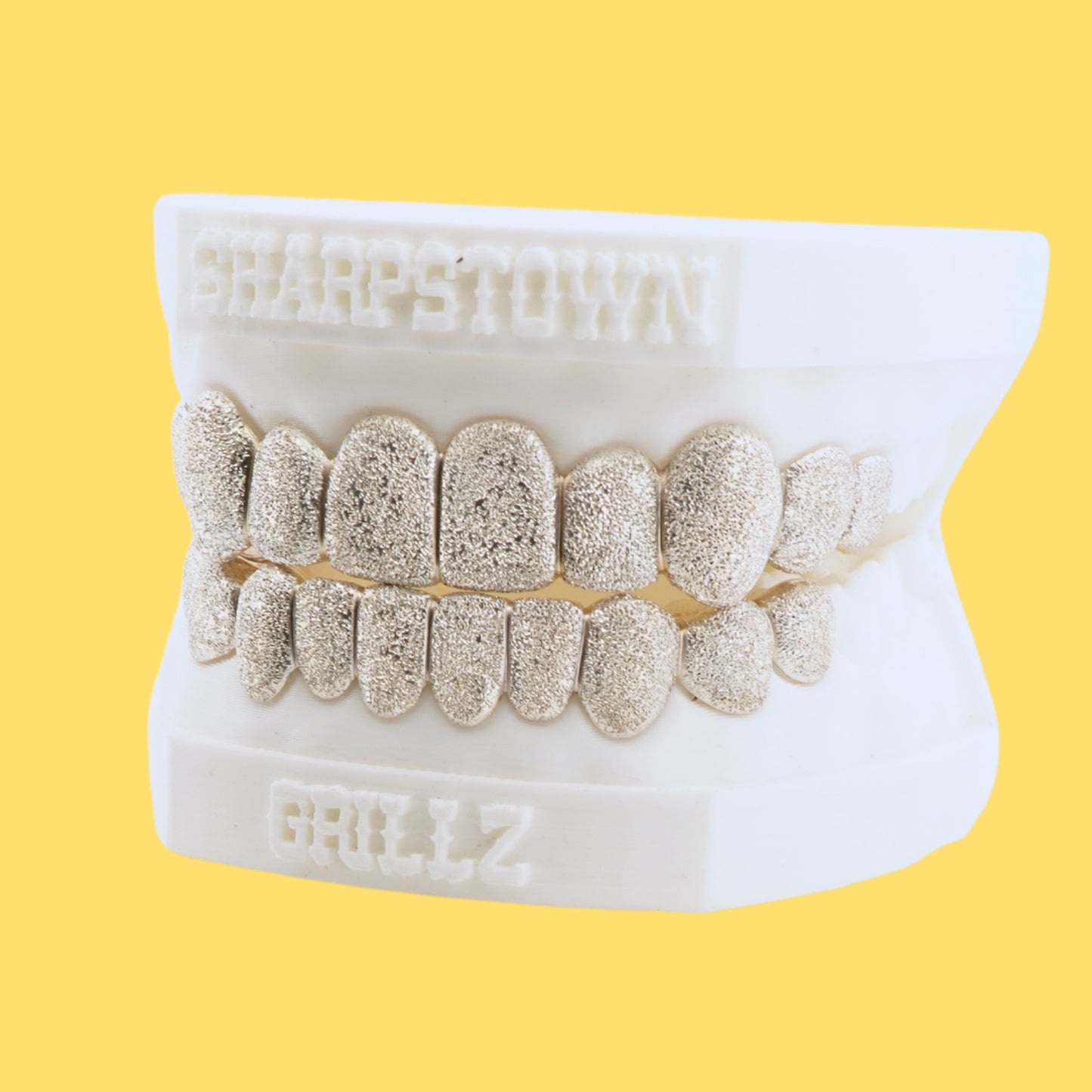 Full coverage diamond dust texture custom grill set in Silver 925 on yellow background.