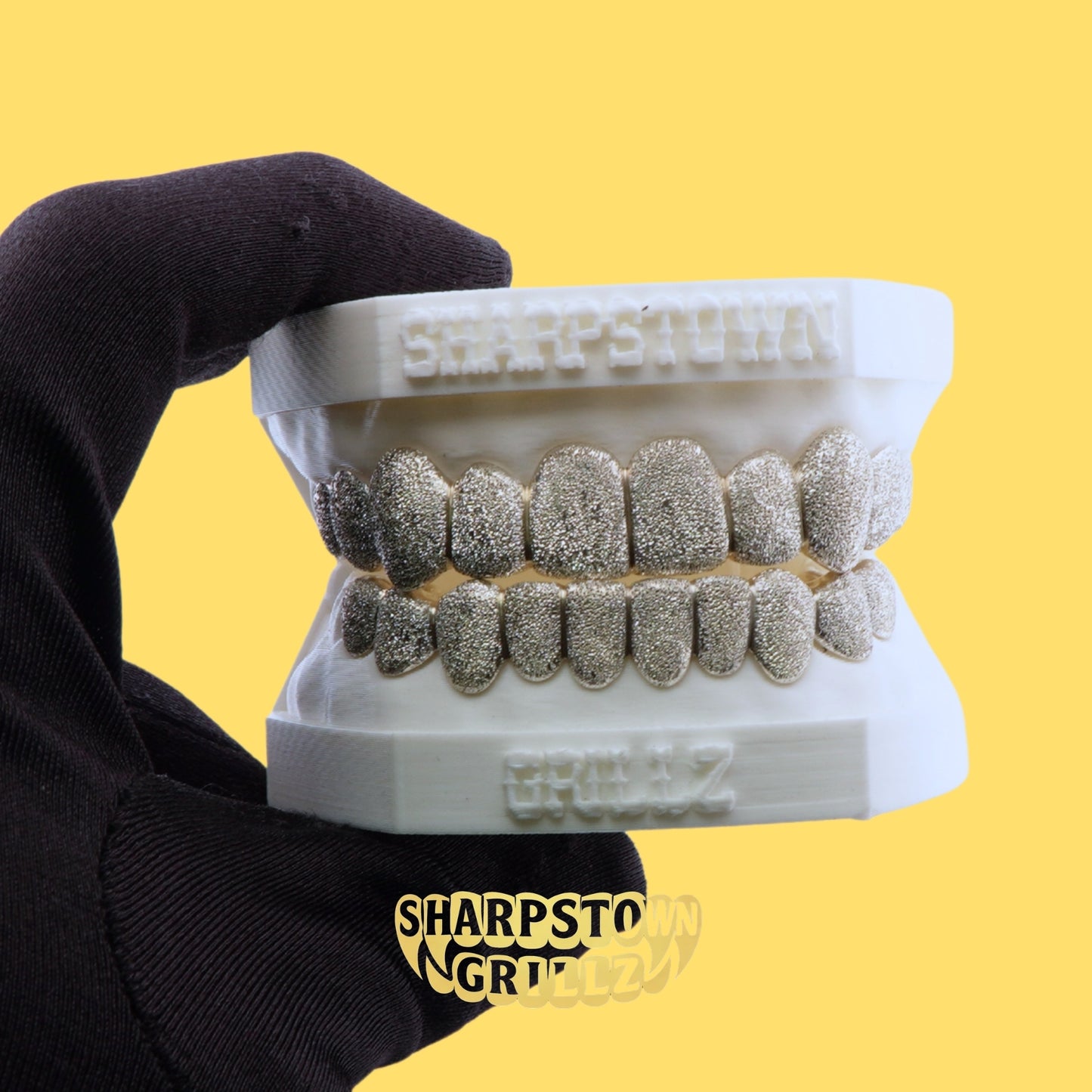 Top and bottom diamond dust stippled custom teeth caps fitted on a 3D dental mold.