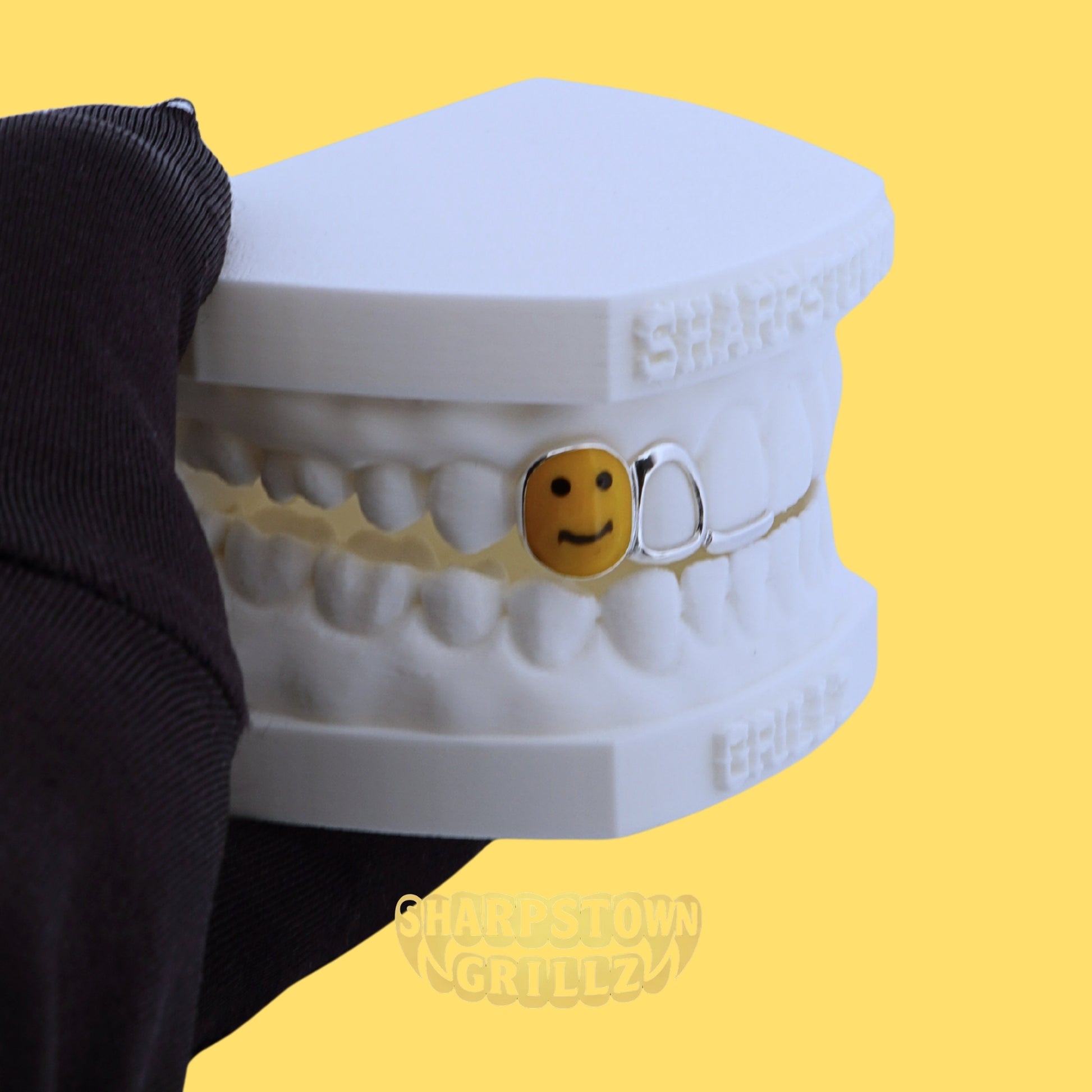 Custom 925 silver smiley face tooth grill with open window frame on upper jaw teeth impression.