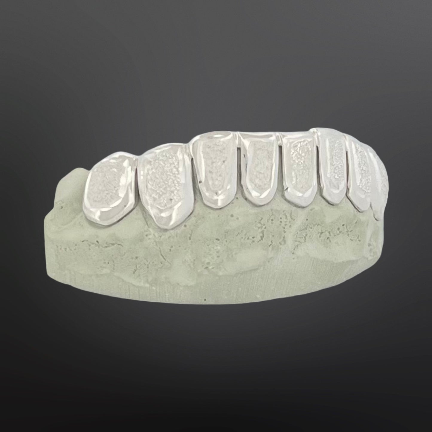Dental model with metallic grill on a dark background
