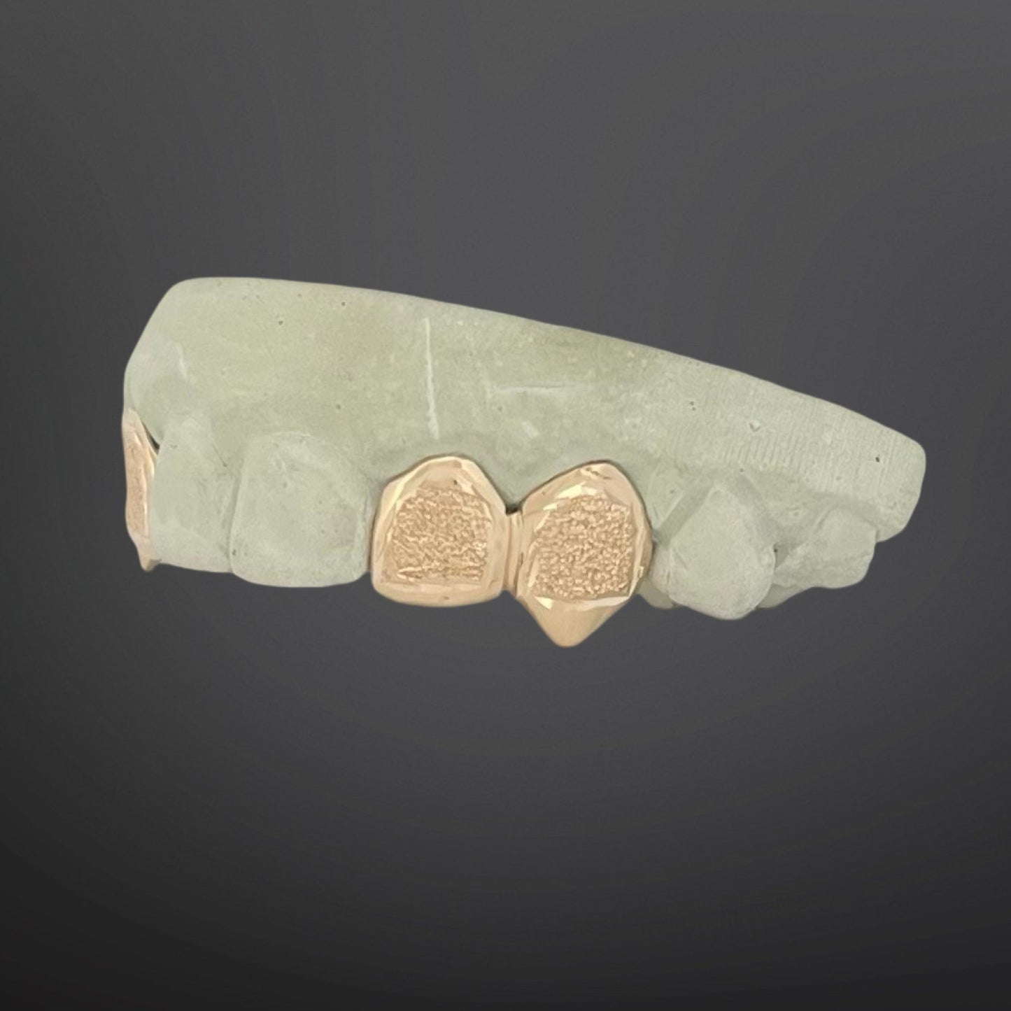 Green stone with gold heart-shaped inlays on a dark background