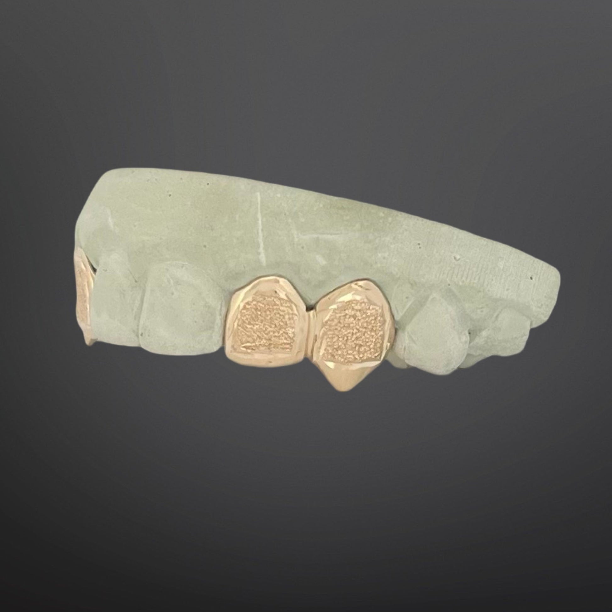 Green stone with gold heart-shaped inlays on a dark background