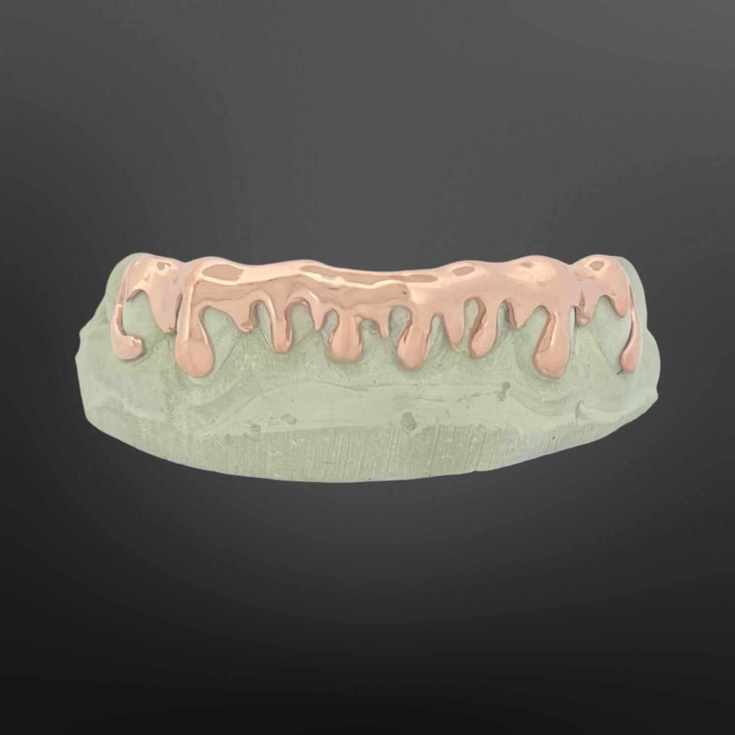 Dental model with pink and green materials on a dark background