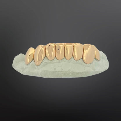 Gold teeth grill on a gray background