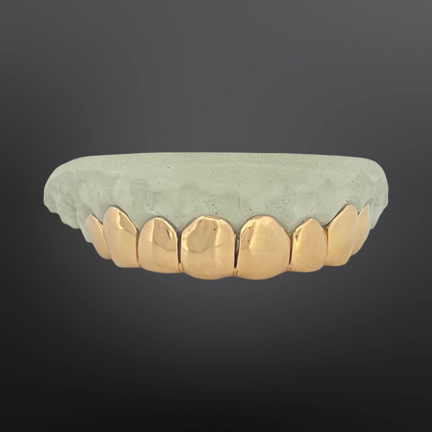 Gold dental grill on a gray background