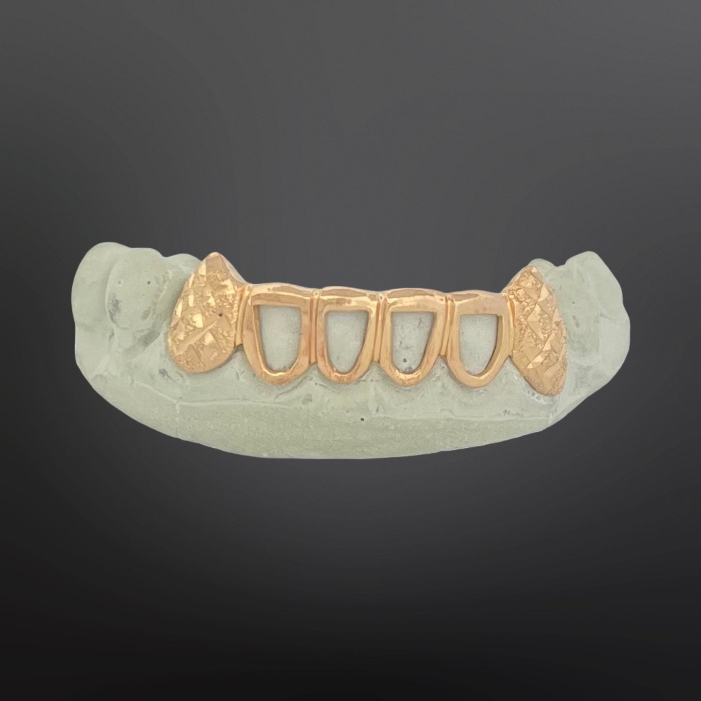 Gold dental grill on a gray background