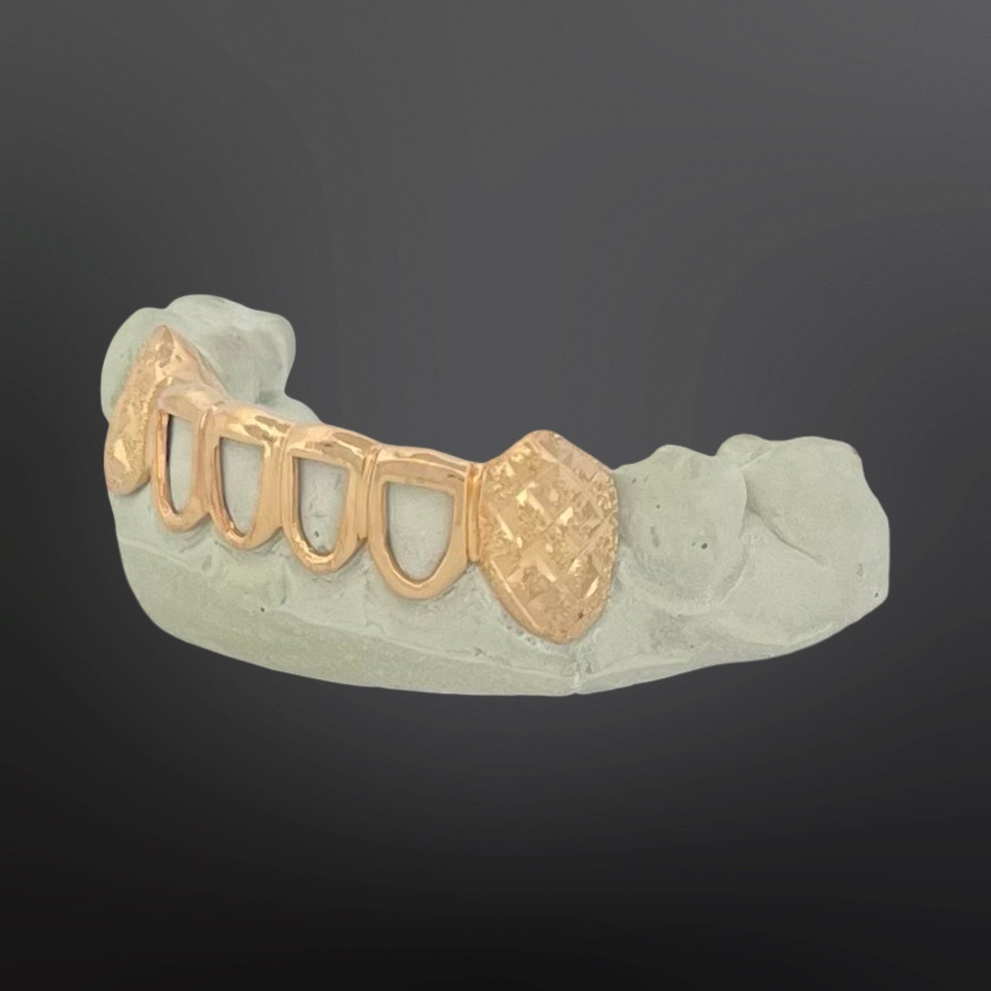 Gold dental grill on a gray background