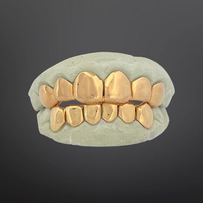 Gold dental grill on a gray background