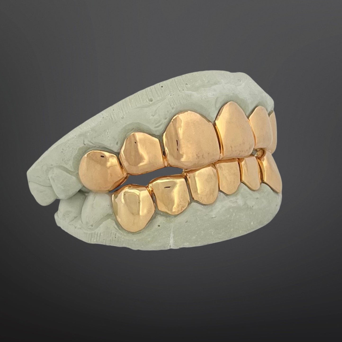 Gold dental grill on a gray background