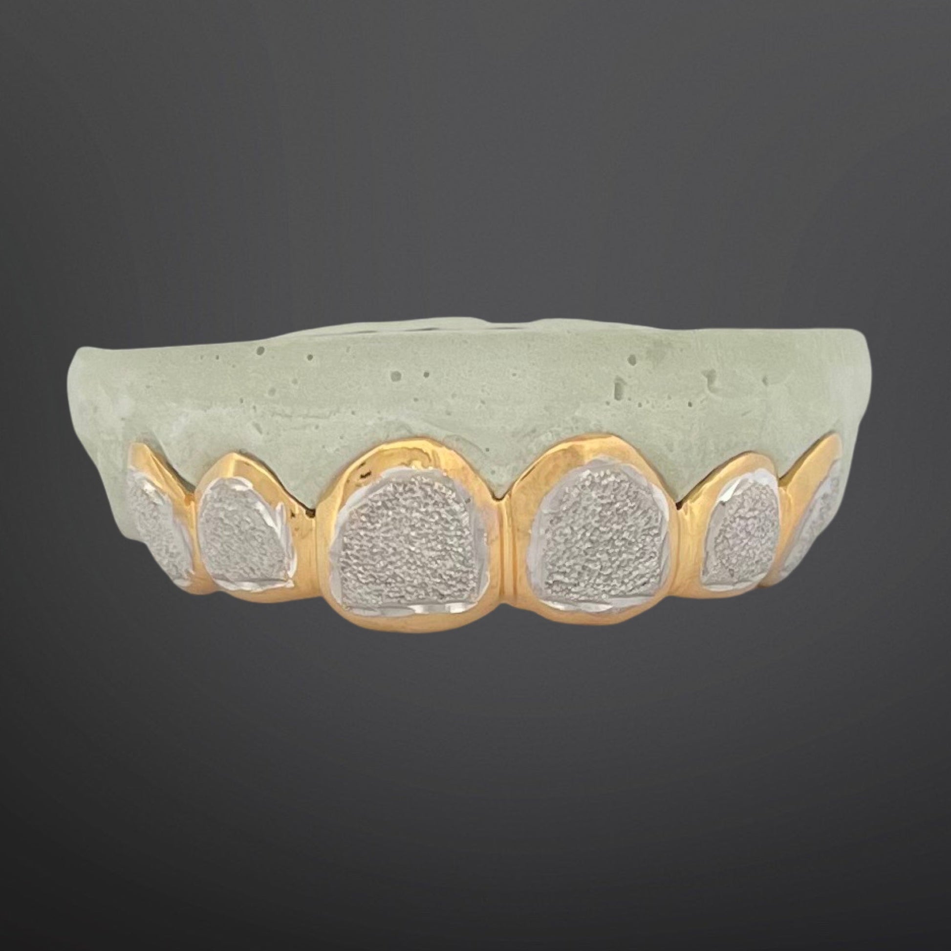 Decorative bowl with textured surface and gold rim on a dark background