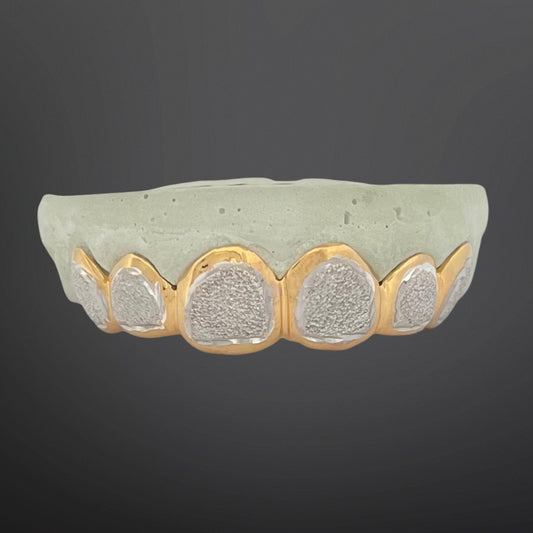 Decorative bowl with textured surface and gold rim on a dark background